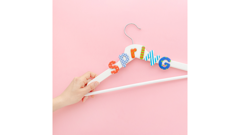 White hangers with sale text on pink background
