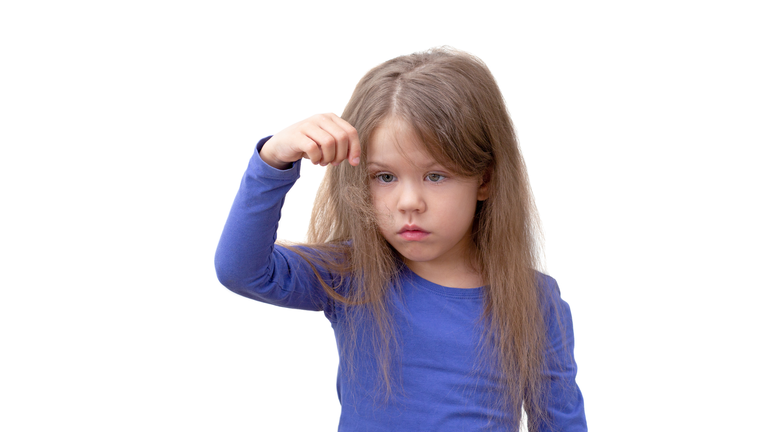 Child with long hair holding piece of hair pulling out