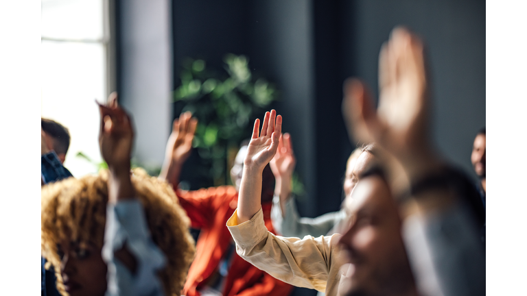 Group of Anonymous People Raising Hands on a Seminar