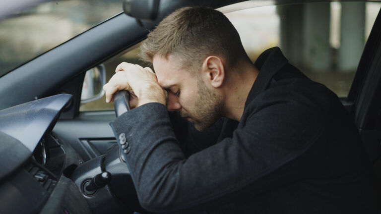 Young man sitting inside car is very upset and stressed