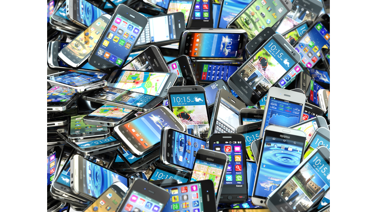 Mobile phones background. Pile of different modern smartphones.