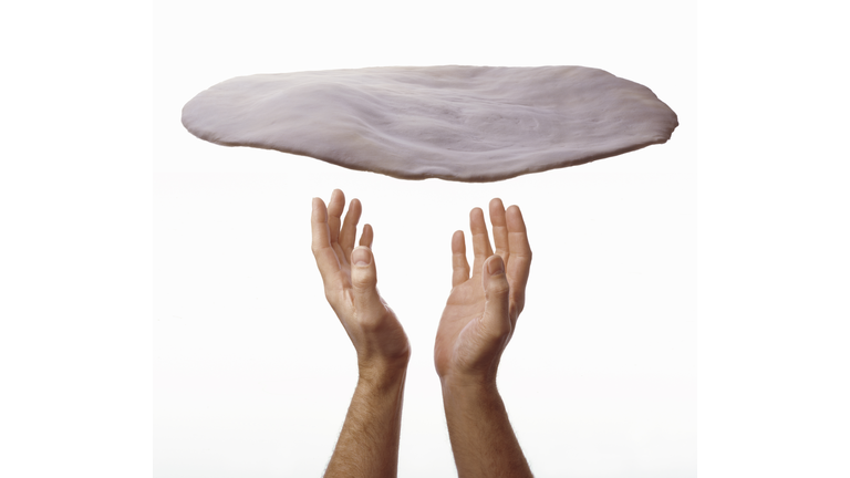 man throwing pizza dough