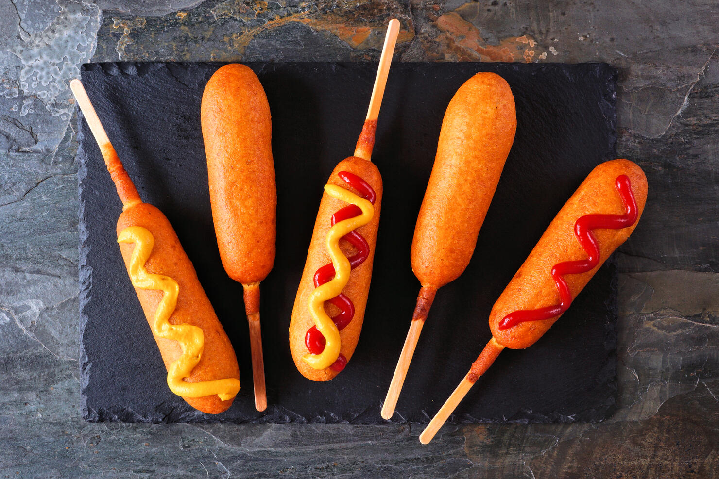 Corn dogs on a slate platter