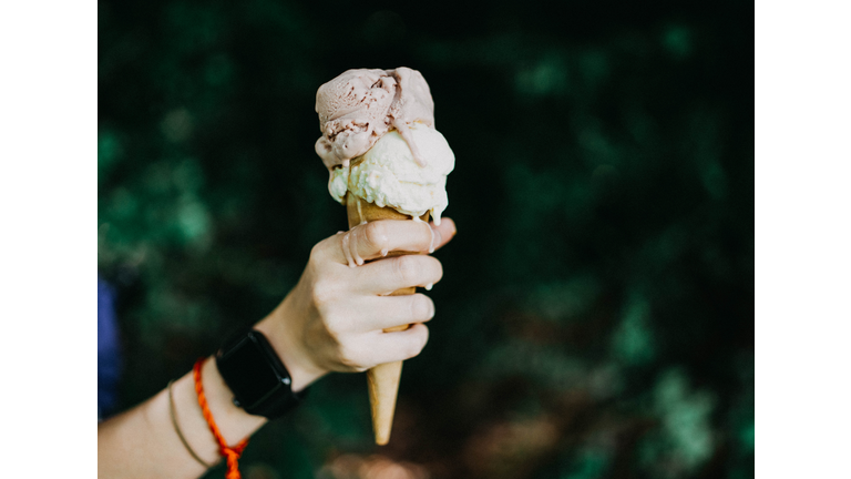 Holding ice cream cone, dripping cream