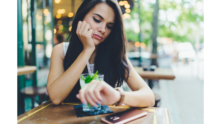 Teenage girl in cocktail bar waiting for her boyfriend