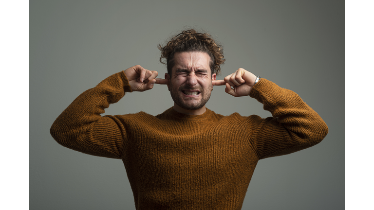 Man covering his ears