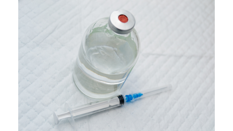 vial with clear drug solution and a syringe