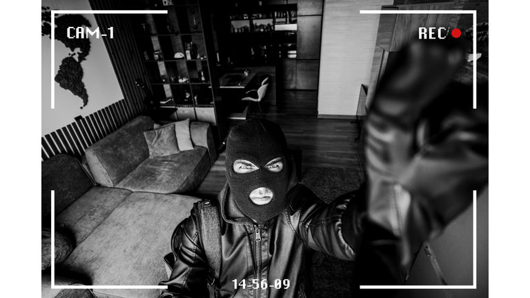 Housebreaking Concept. Intruder sneaking into house at night, holding crowbar, top view from above camera, high angle. criminal breaks the camera in the house. robber noticed a security camera.