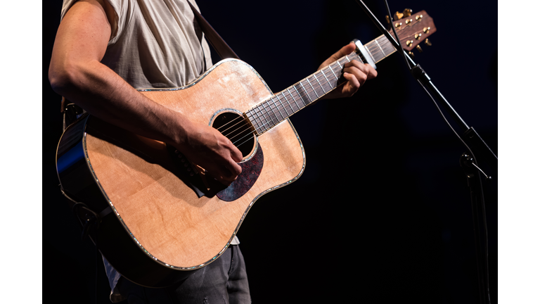 Guitarist - Singer playing the guitar during his concert