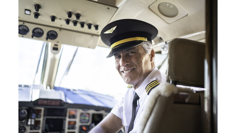 Portrait of airplane pilot looking over shoulder in a private jet