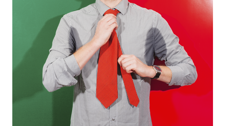 Midsection of businessman with sweaty armpits wearing necktie against colored background