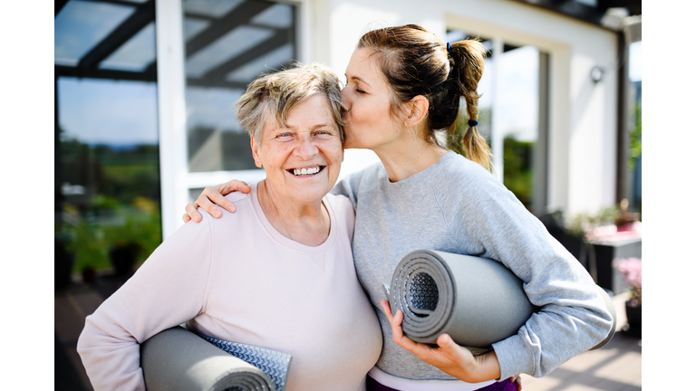 Portrait of woman with senior mother resting after exercise outdoors.