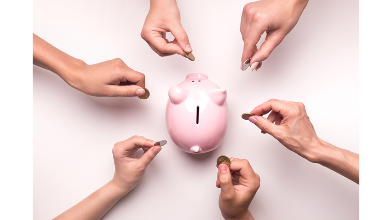 People hands throwing coins in piggy bank for crowdfunding