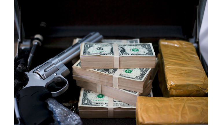 Gun with bullets lying on the table. Criminal problems. Drugs and money on black background. Illegal selling.