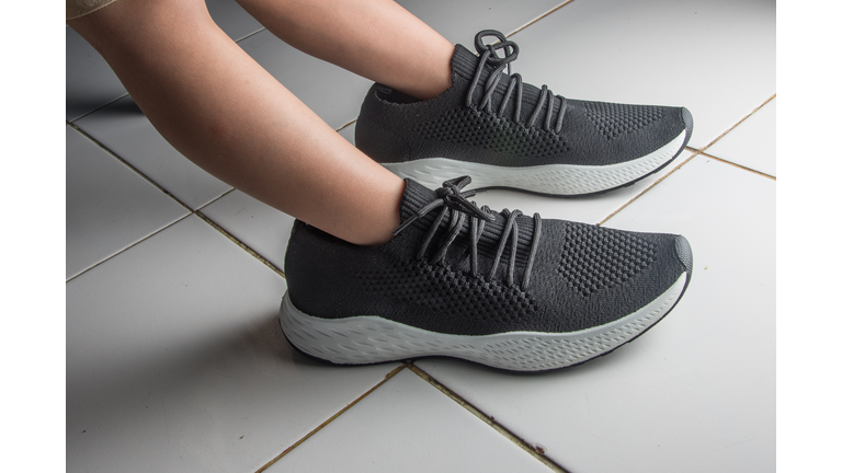 little boy's feet wearing oversized black shoes