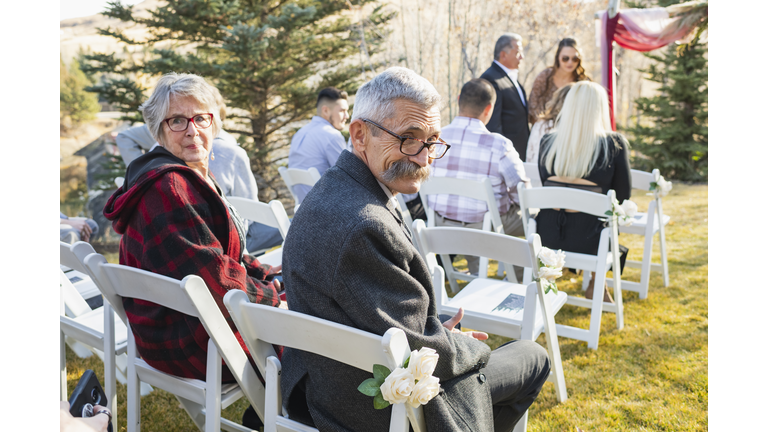 Wedding guests seated outdoors awaiting ceremony