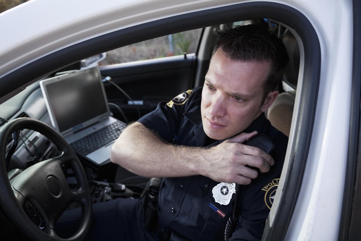 Police officer sitting in cruiser
