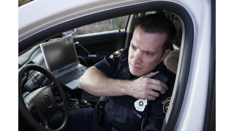 Police officer sitting in cruiser