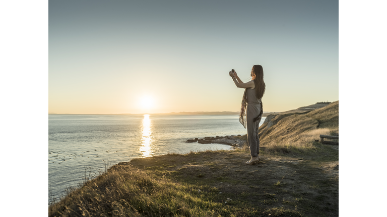 asian beautiful woman taking  picture at cliff