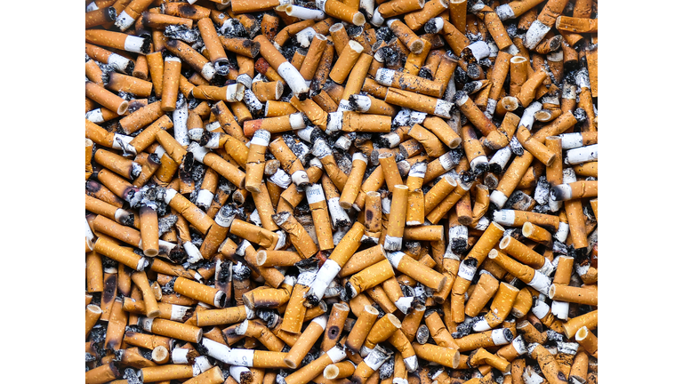 Cigarette butts in a public ashtray.