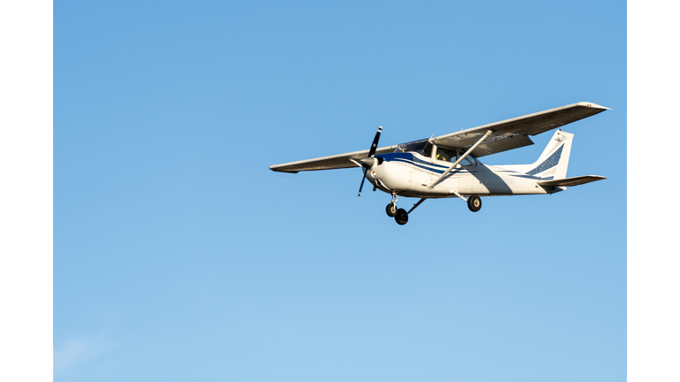 Small plane flying with sunset light in a clear sky before landing on Sabadell Airport.