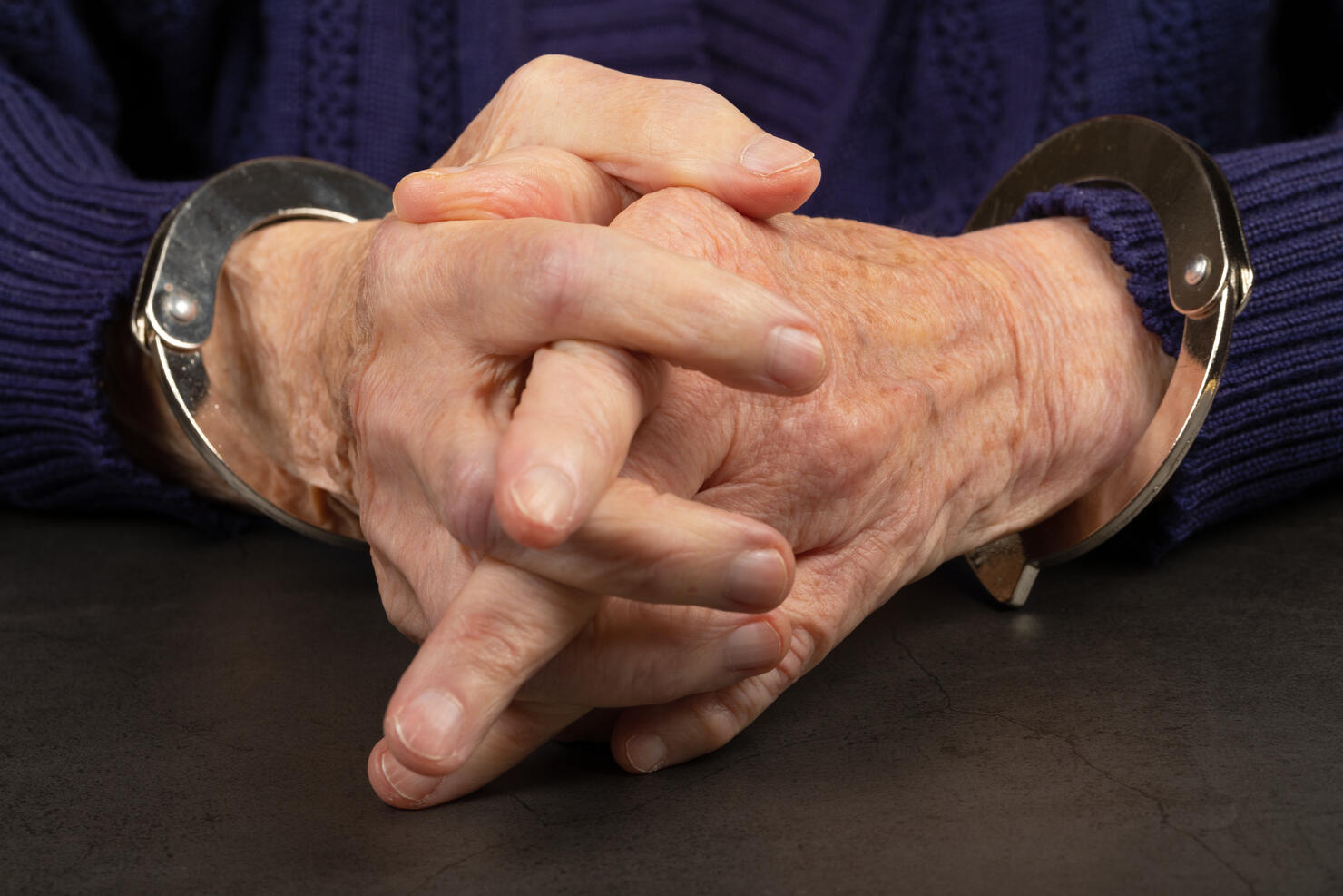 Handcuffed  elderly woman