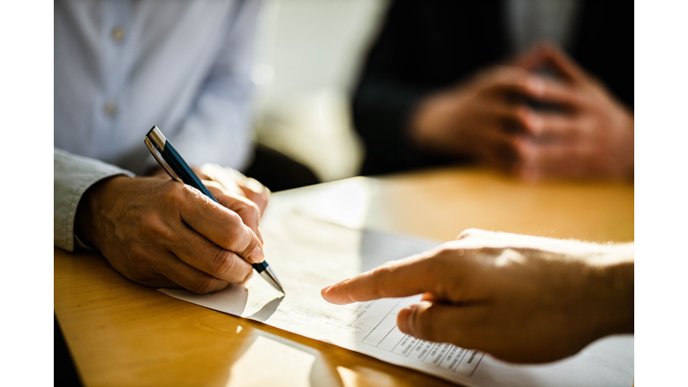 Close up of unrecognizable person signing a contract.