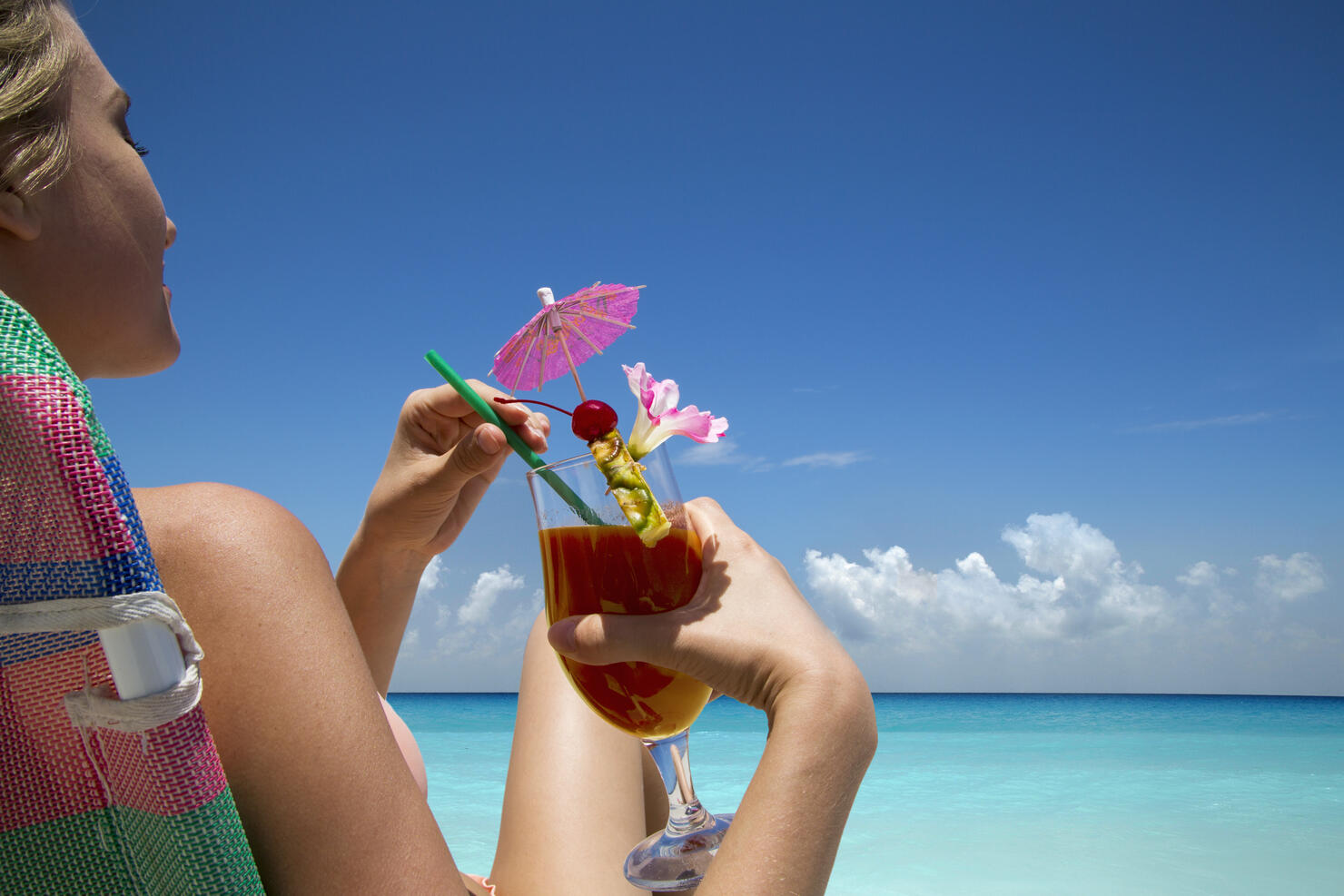 Woman with tropical drink on beach