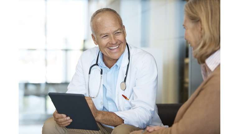 Happy doctor discussing with patient in hospital