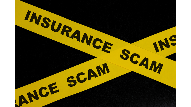 Insurance scam and fraud alert, caution and warning concept. Yellow barricade tape with word in dark black background.