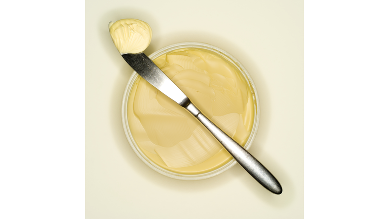 Margarine curl lying on back of a knife, elevated view