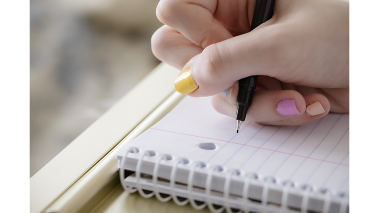 Teen girl beginning to take notes during virtual school