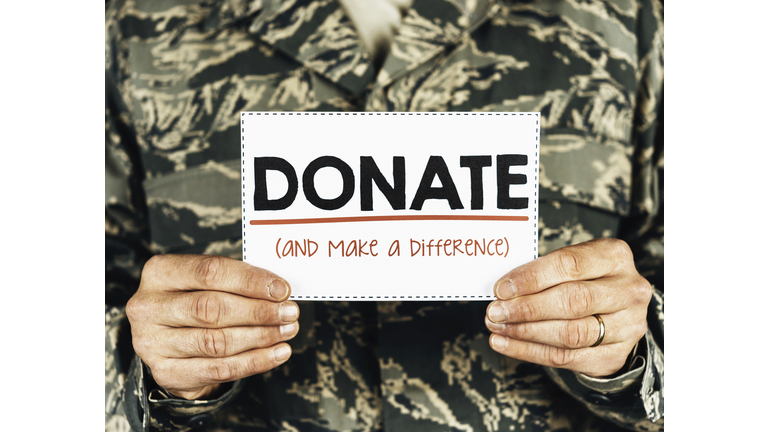 Military service member with donate sign