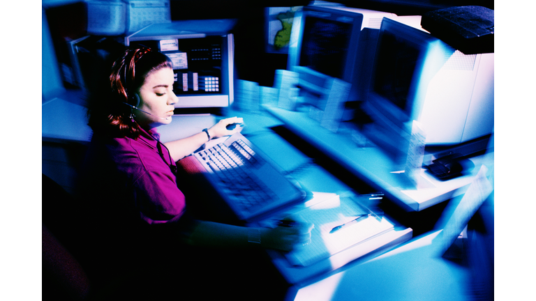 Woman working at police dispatch terminal