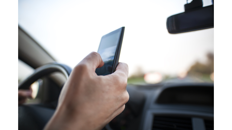 Man using smartphone whilst driving. Internet addicted