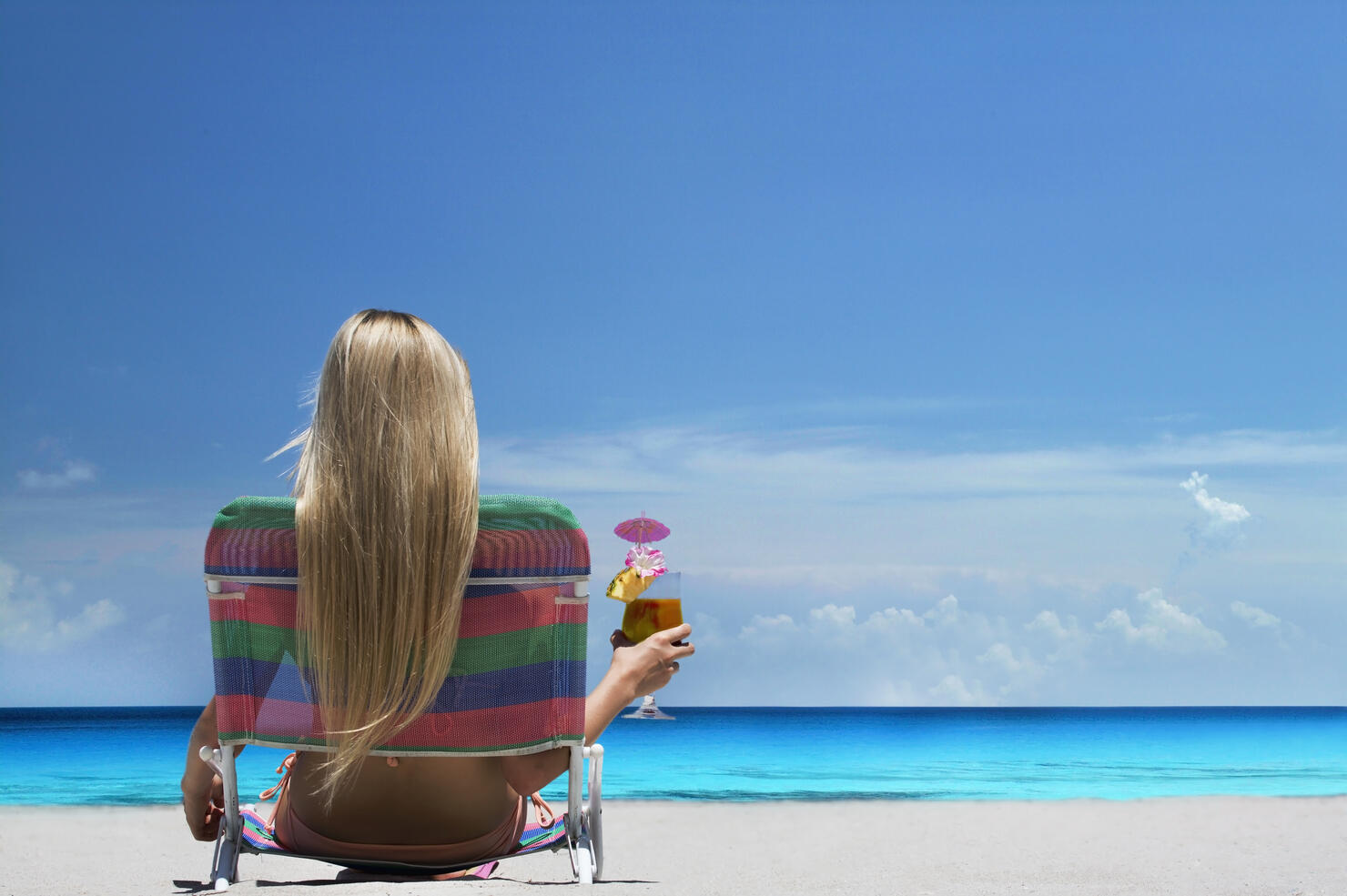 Woman relaxing in lawn chair on beach
