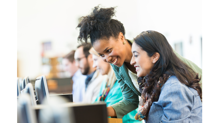 Diverse mid adult students using computers during class in college