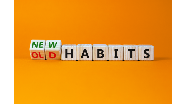 New or old habits symbol. Turned wooden cubes, changed words 'old habits' to 'new habits'. Beautiful orange table, orange background. Business, old or new habits concept. Copy space.