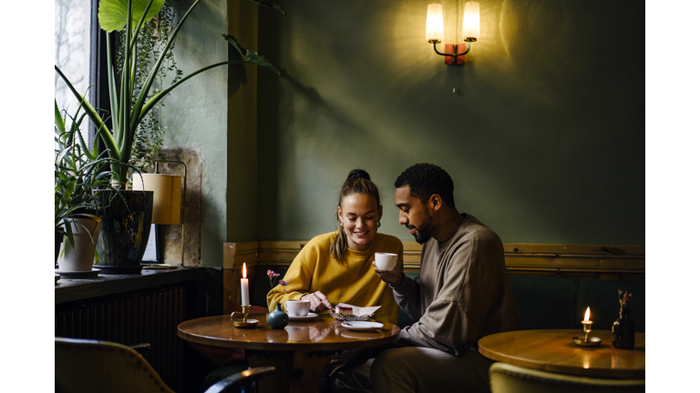 Wide shot with copy space of couple sharing a dessert in cafe