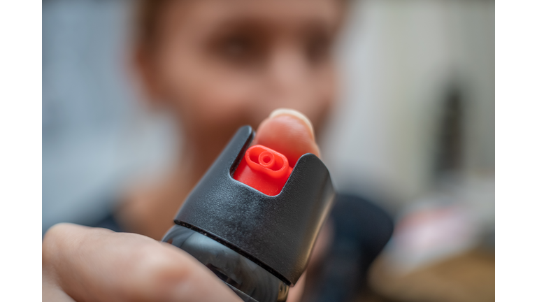 Close up of pepper spray in the girl's hand in the room