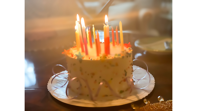 festive birthday cake with candles being lit