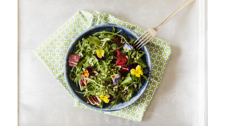 Bowl with salad, lamb's lettuce, rucola, radicchio and edible flowers