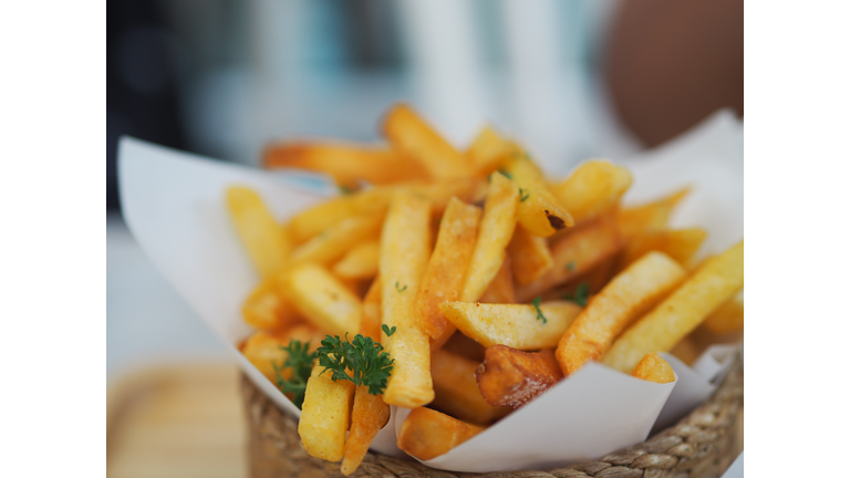 Closeup French fries, Potato chips Yellow crispy fries in wooden basket on white table, snack delicious food