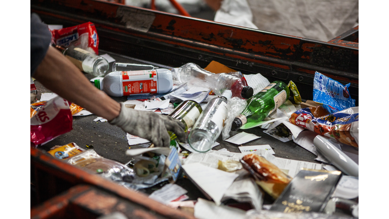 Worker selecting recycable materials on conveyor belt