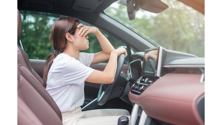 woman feeling stress and angry during drive car long time. Asian girl tired and fatigue having headache stop after driving car in traffic jam. Sleepy, stretching and drunk concept