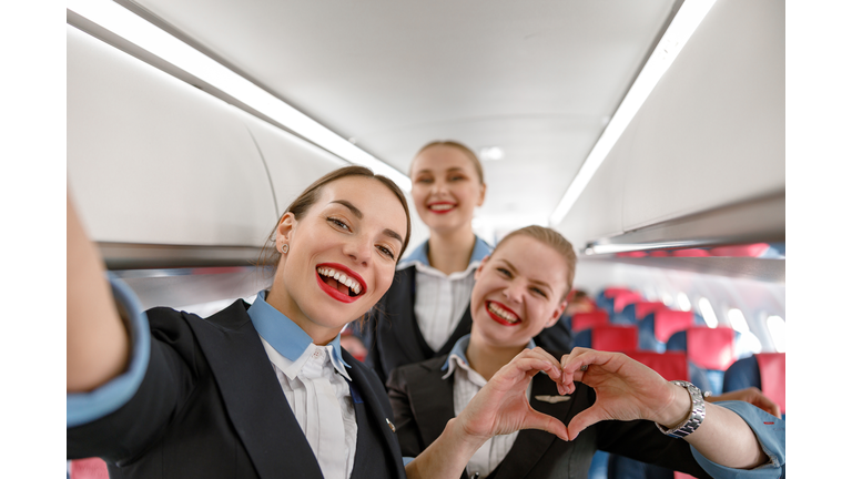 Cheerful flight attendants having fun in airplane