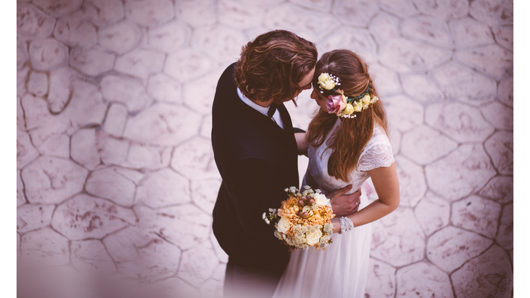 Affectionate bride and groom embracing and dancing at wedding reception