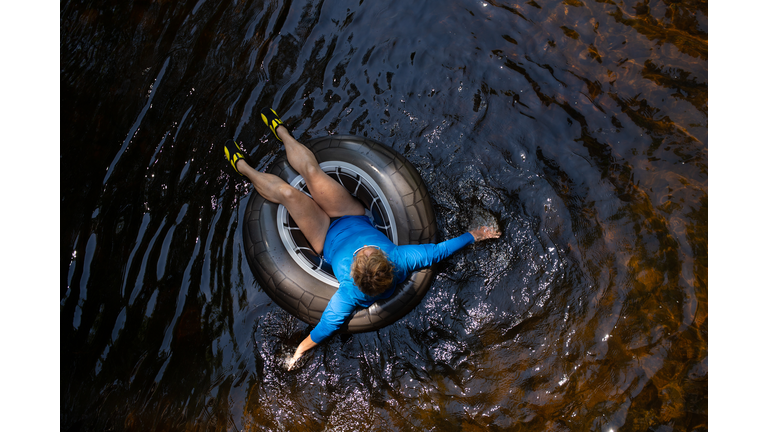 Woman floating down a river in inner tube