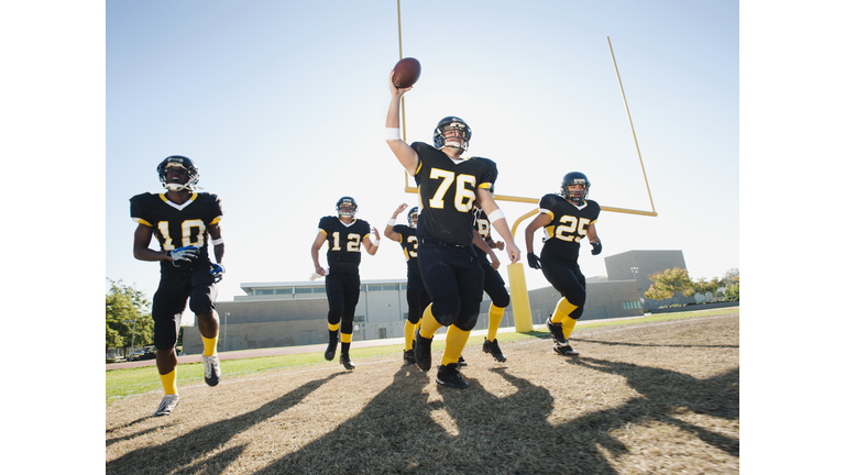 Football players celebrating on football field