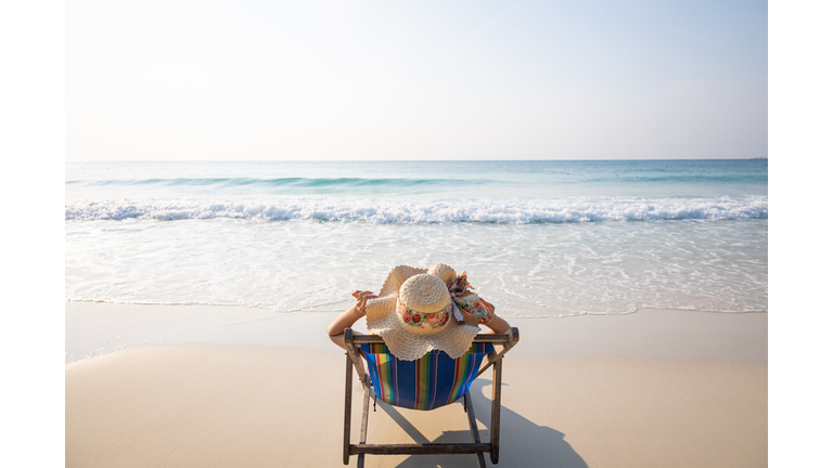 Woman relaxing in lawn chair on beach